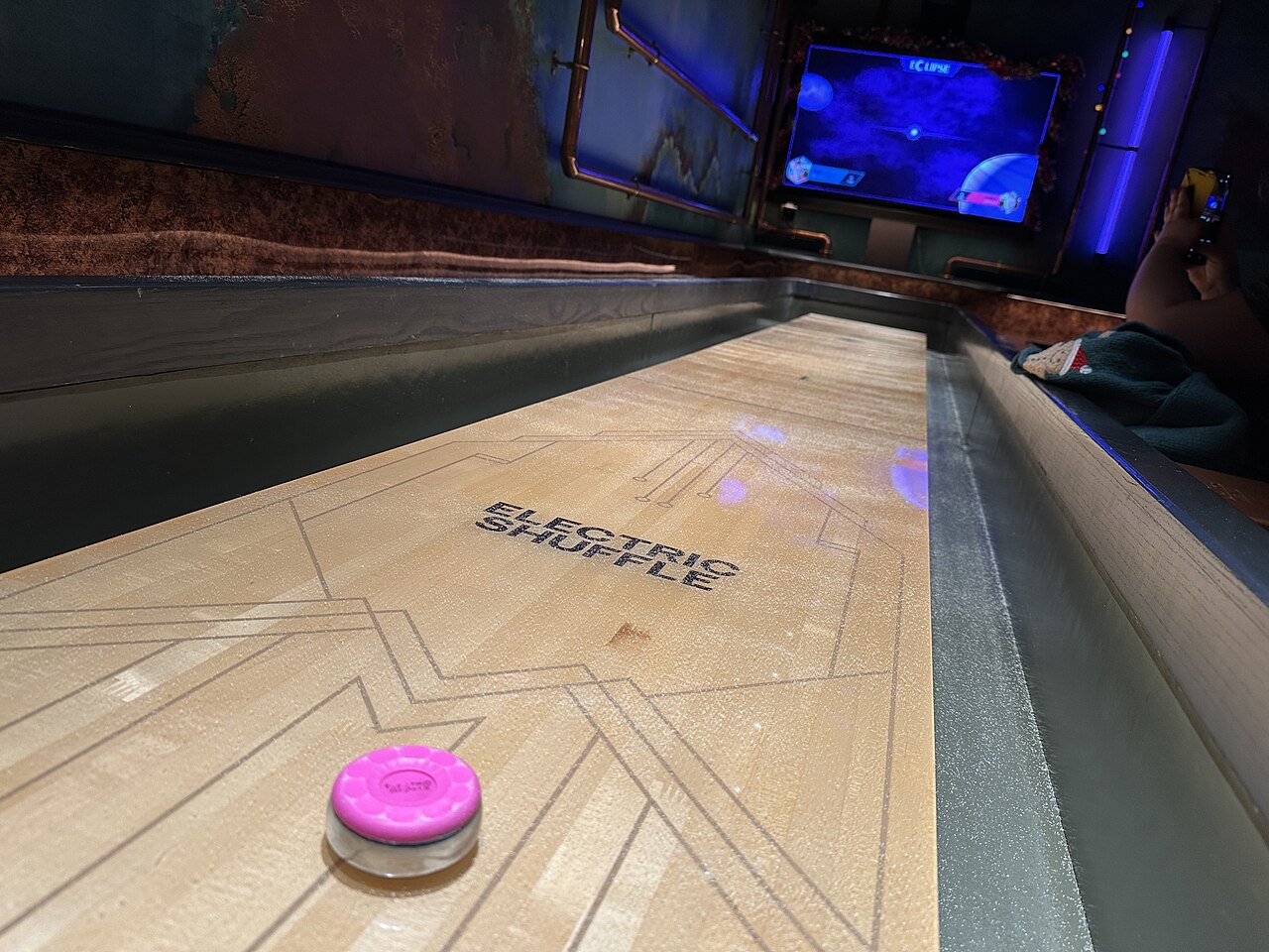 A shuffleboard table in play at Electric Shuffle, Canary Wharf
